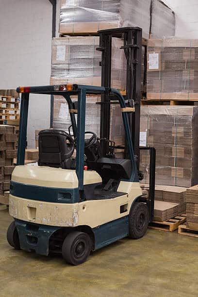 Forklift amid rows of boxes in a large warehouse